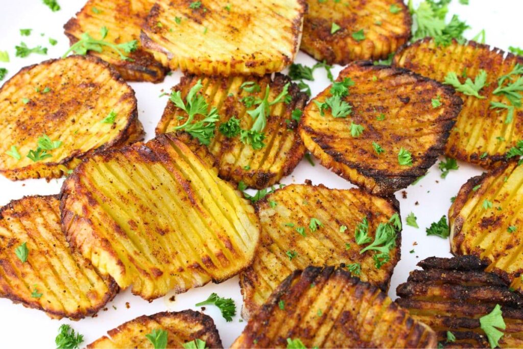 air fryer accordion potatoes on a plate sprinkled with fresh herbs