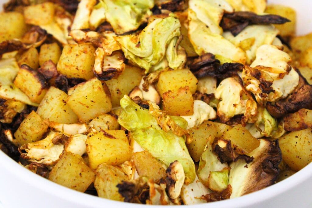 closeup view of air fryer cabbage and potatoes mixed together in a bowl