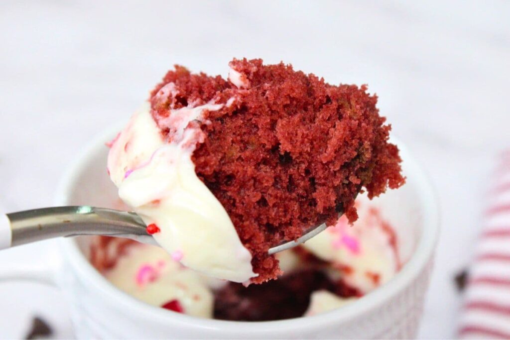 holding up a spoonful of red velvet mug cake