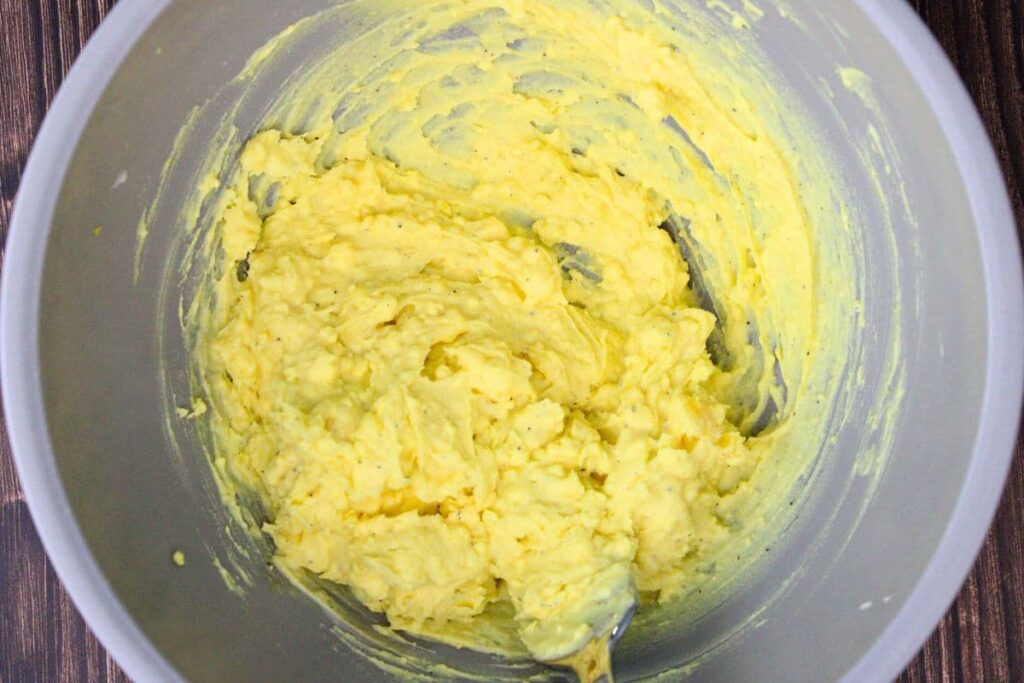 add mayonnaise, miracle whip, mustard, salt, and pepper to the egg yolks and mix