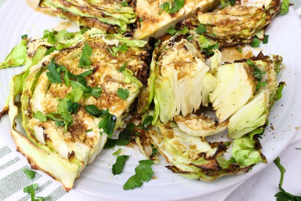 air fryer cabbage wedges on a plate sliced open with balsamic drizzle