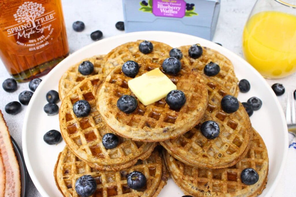 air fryer trader joes blueberry waffles on a plate with butter and fresh blueberries