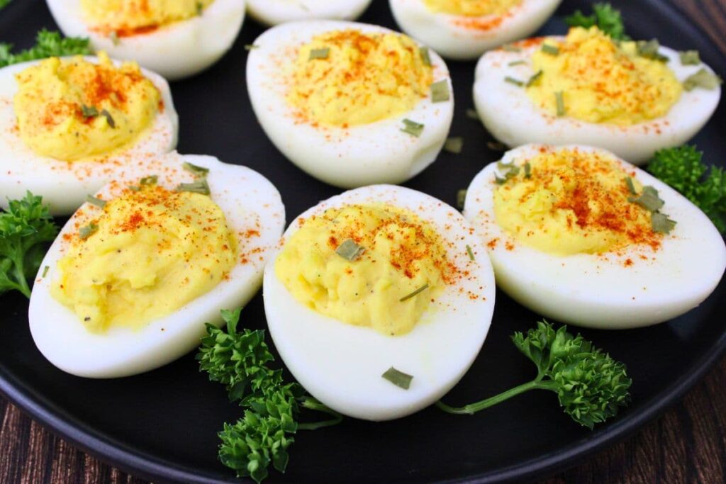 closeup view of several air fryer deviled eggs sitting on a black plate
