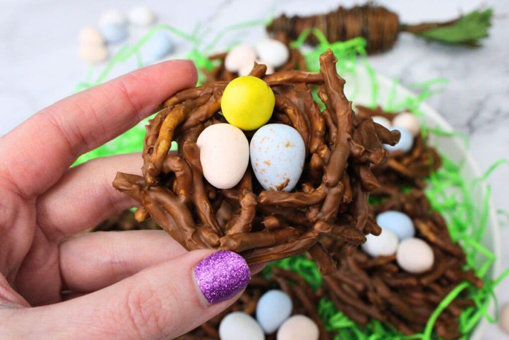 holding up a birds nest treat with candy eggs