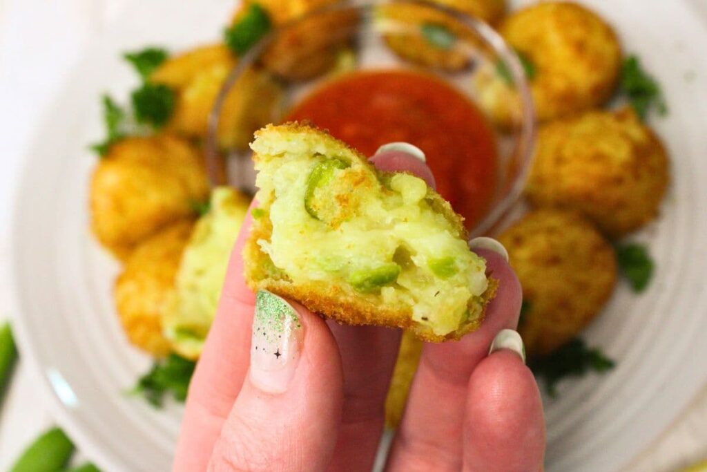 holding up a cross section of an air fried frozen arancini