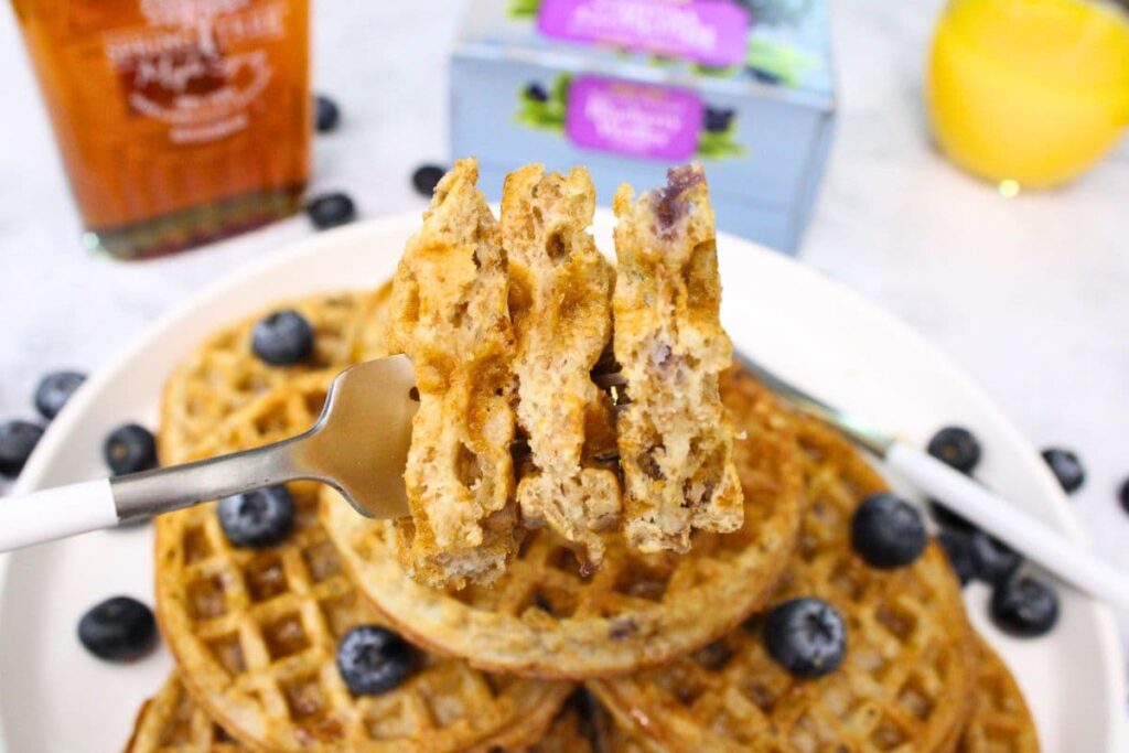holding up a fork with pieces of trader joes blueberry waffles