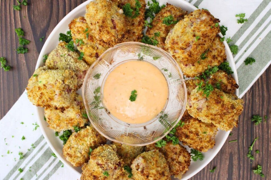 overhead view of reuben croquettes circling a plate with thousand island dipping sauce in the center