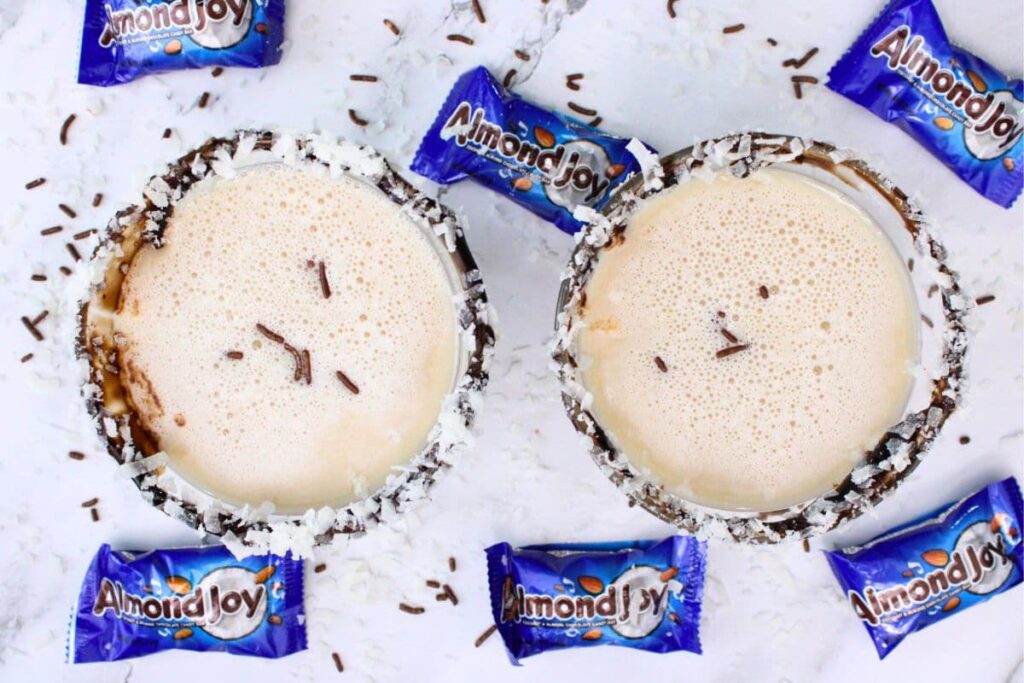 overhead view of two almond joy martini cocktails surrounded by almond joy candy bars