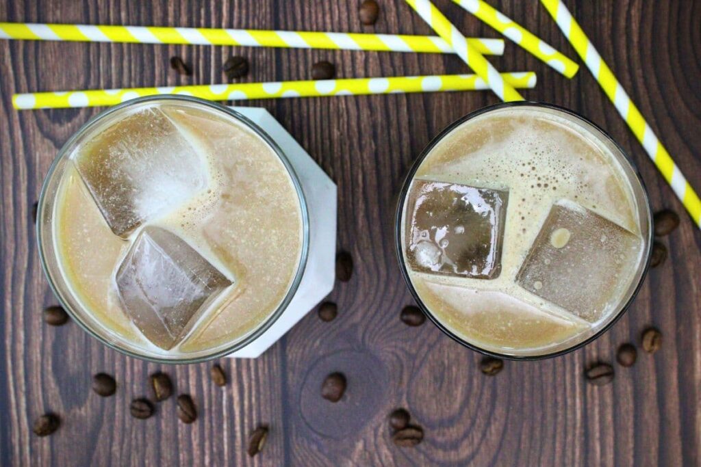 overhead view of two long island iced coffee drinks with ice in whiskey glasses