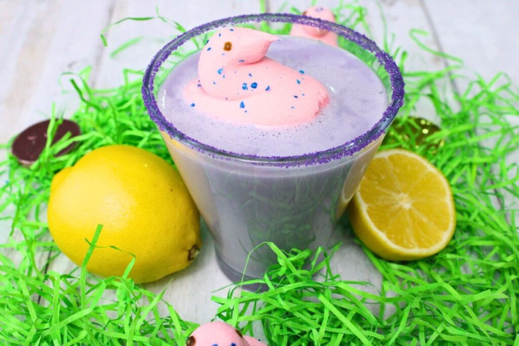 peeps martini drink with marshmallow chick and fresh lemon on top of fake Easter grass