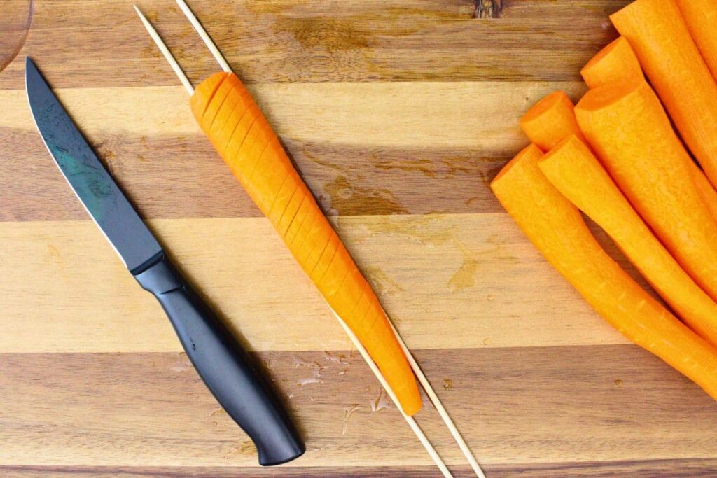 place carrot on chopsticks so you do not cut all the way through