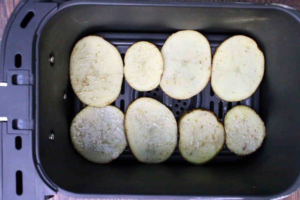 place seasoned potato slices in air fryer basket