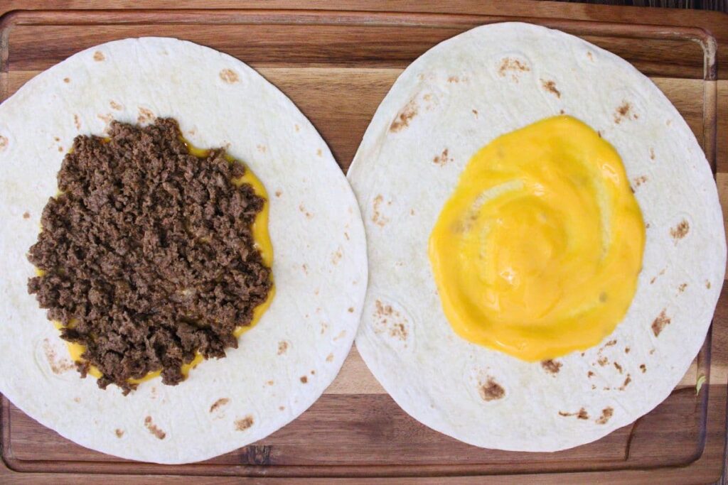 add nacho cheese and cooked ground beef to large tortilla shell