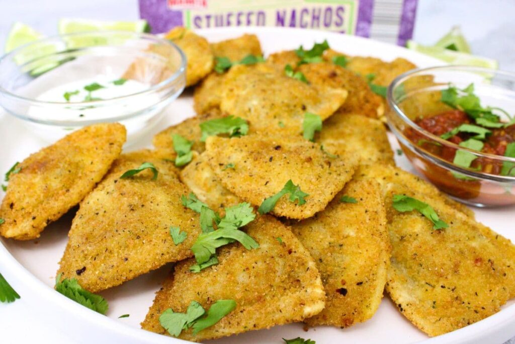 aldi casa mamita stuffed nachos spread across a plate with salsa and sour cream dipping bowls