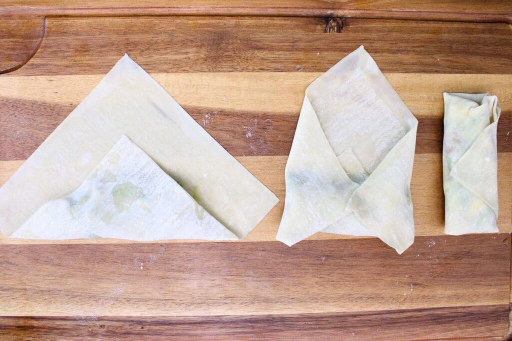 carefully fold the egg roll wrapper over the avocado filling