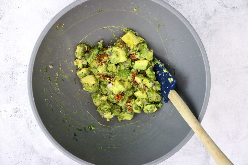 combine avocado chunks, sundried tomatoes, red onion, cilantro, salt, and lemon juice in a mixing bowl