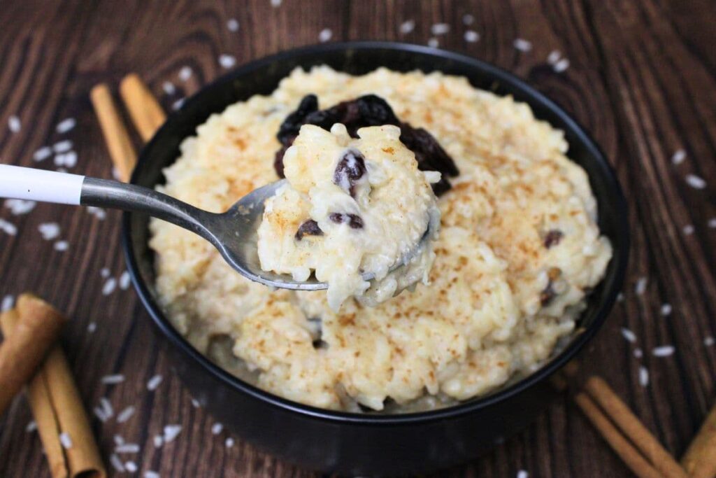 holding up a spoonful of rice pudding with raisins