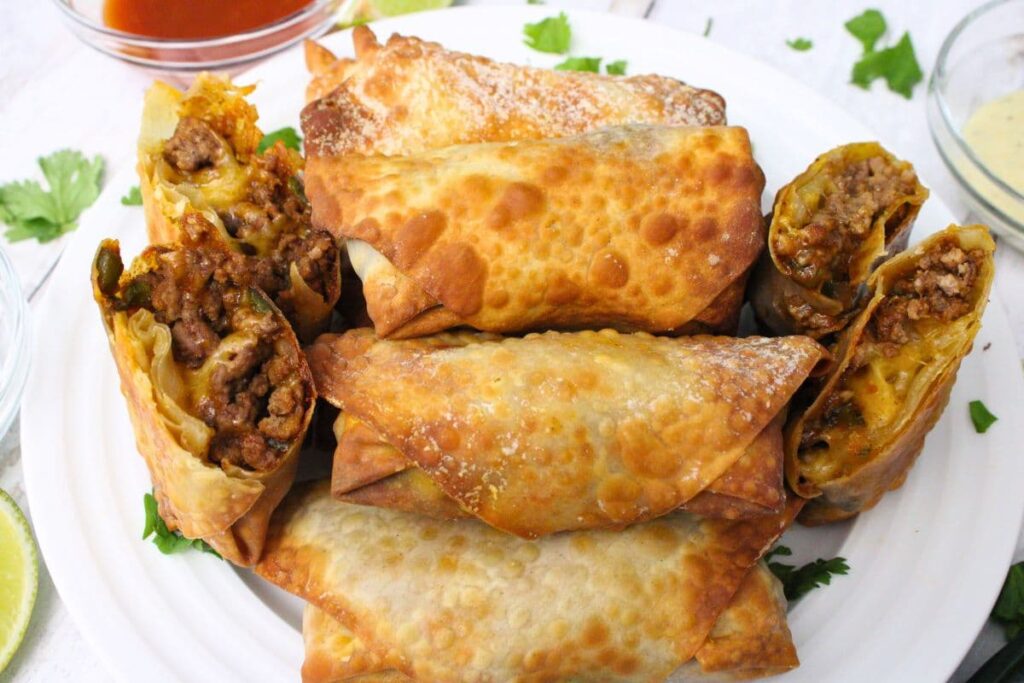 stack of taco egg rolls on a plate bookended by cut in half egg rolls