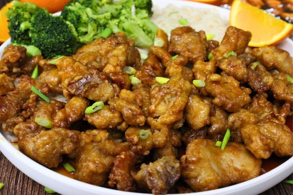 closeup view of air fryer trader joes orange chicken on a plate with rice and broccoli