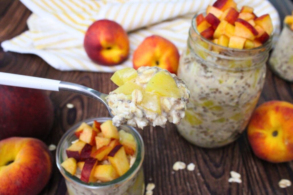 holding up a spoonful of canned peach overnight oats