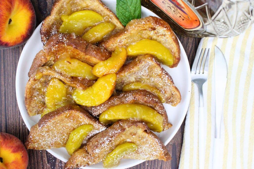 overhead view of air fryer crown royal peach whiskey french toast on a plate with fresh peaches