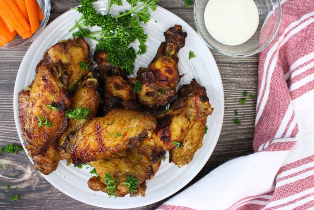 overhead view of air fryer reheated leftover chicken wings on a plate