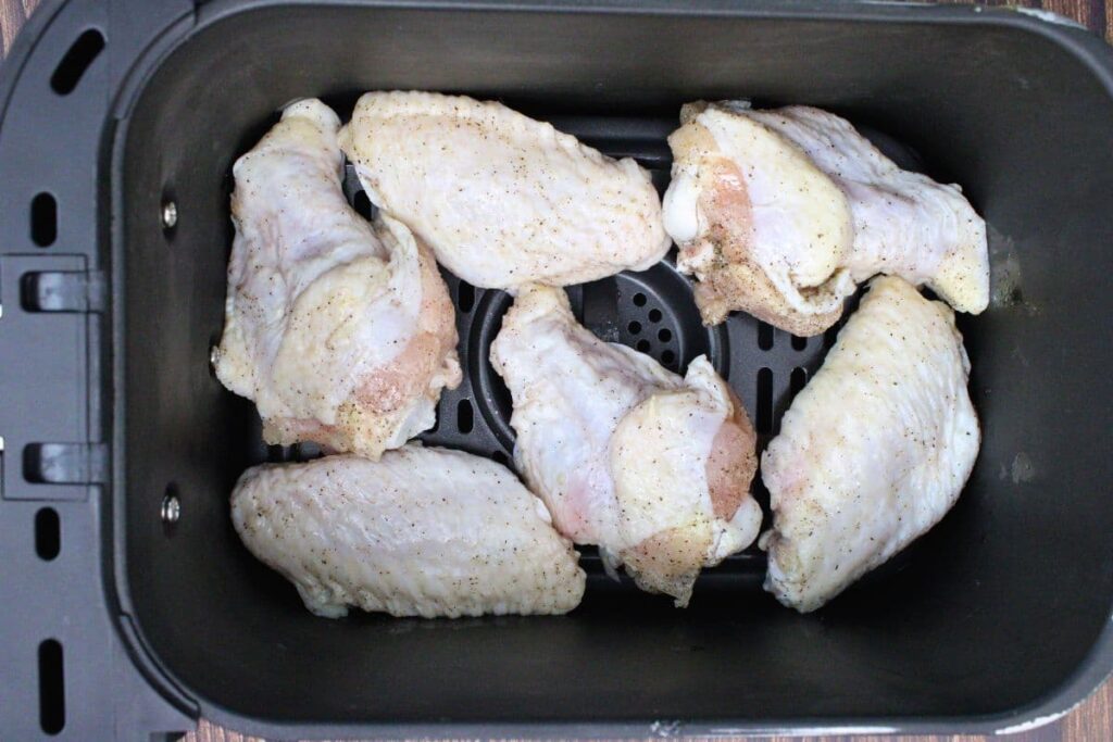 place seasoned chicken wings in air fryer basket