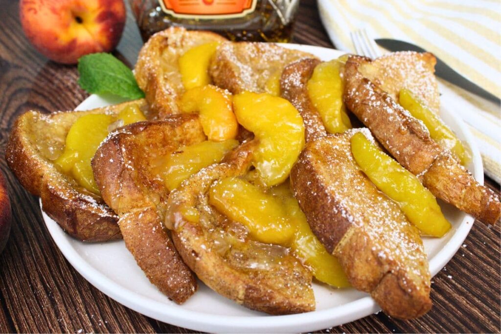 slices of crown royal peach whiskey french toast with a fresh peach sauce topping