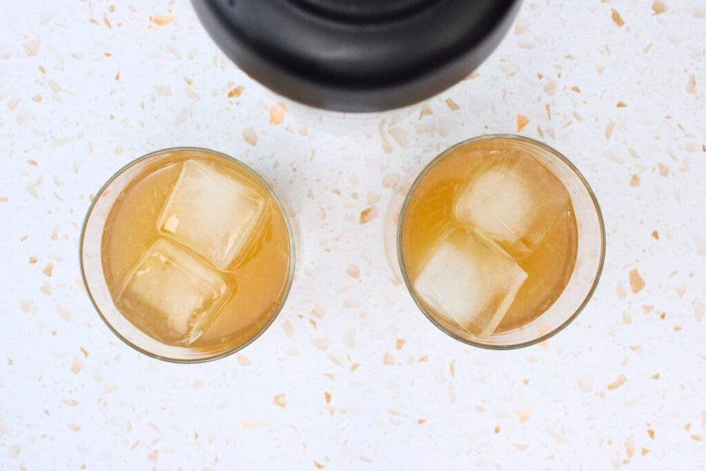 strain peach whiskey sour into glass