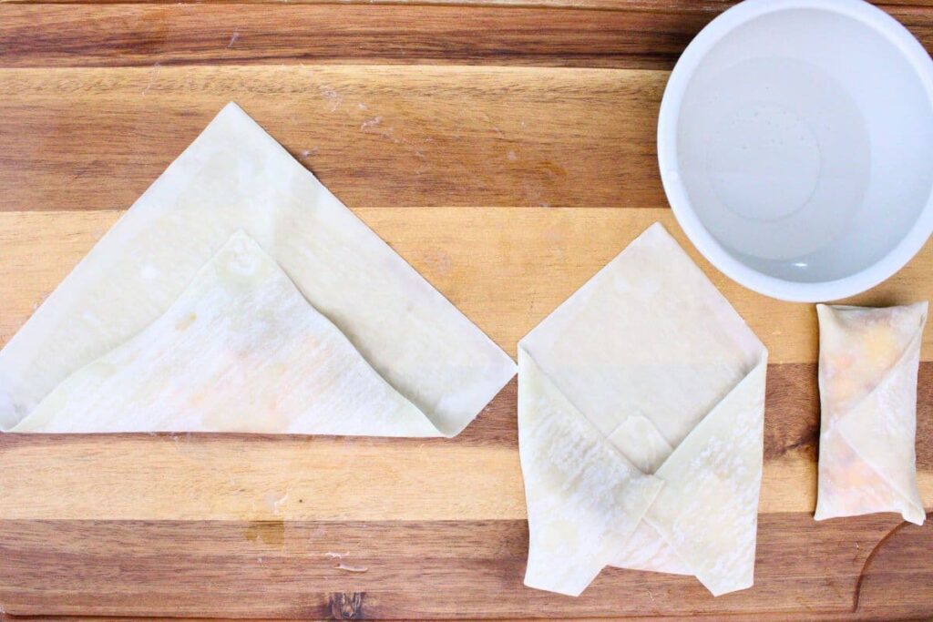 carefully fold egg roll wrapper over peach filling