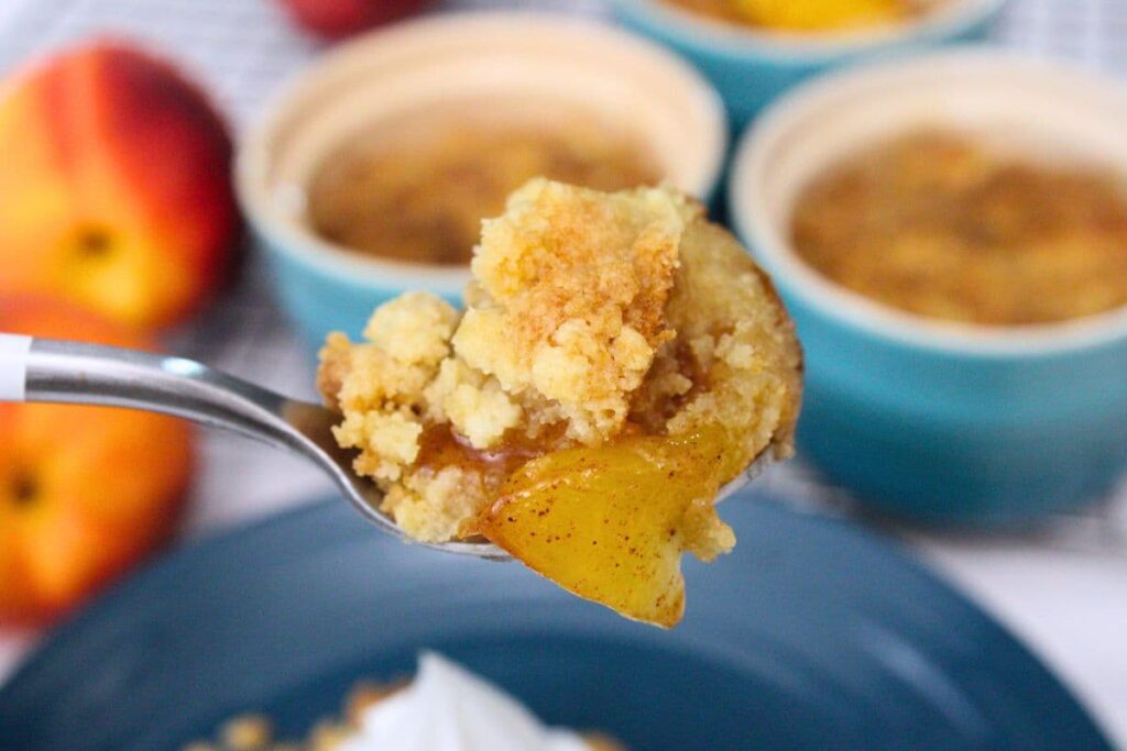 holding up a spoonful of air fryer peach crumble