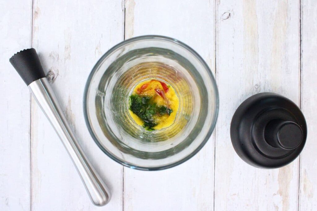 muddle mint leaves, peach slices, and brown sugar in a cocktail shaker
