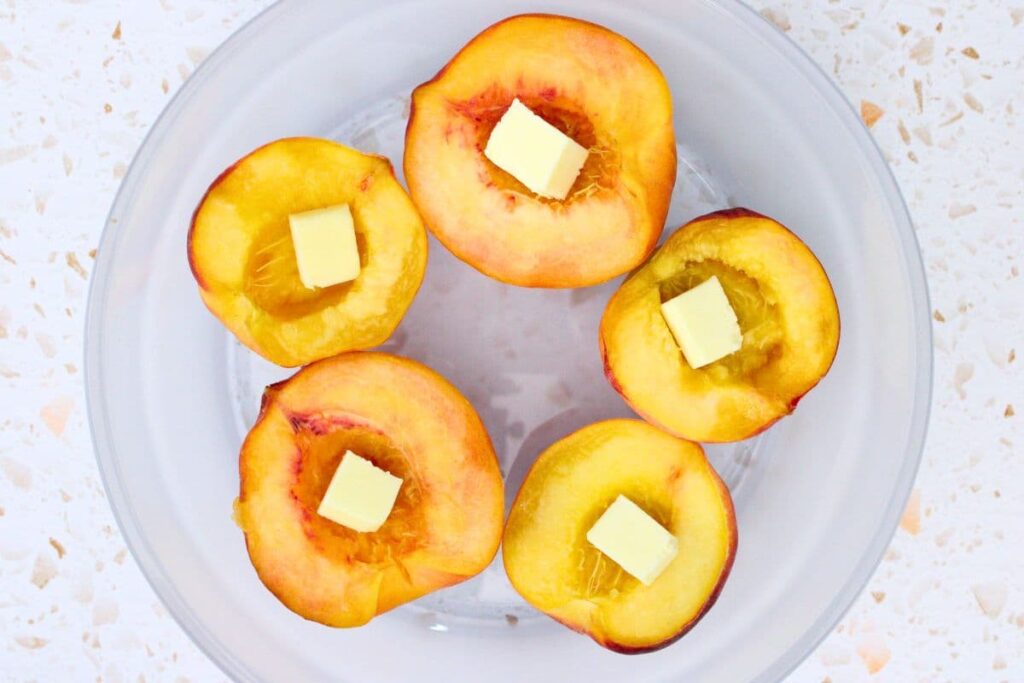 place a quarter of butter in the center of each peach half