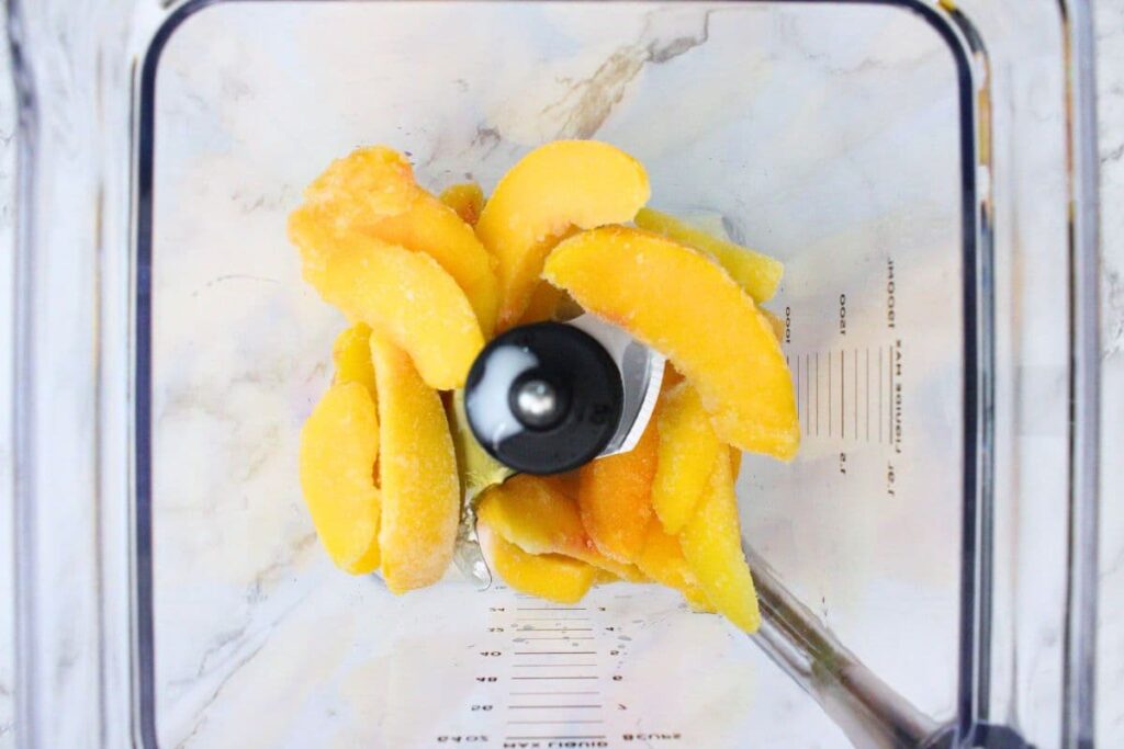 add banana, almond milk, honey, and frozen peaches to blender