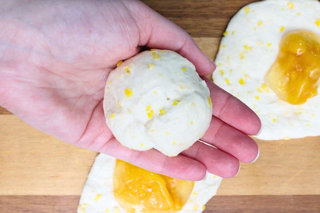 close dough around peach pie filling by forming a ball