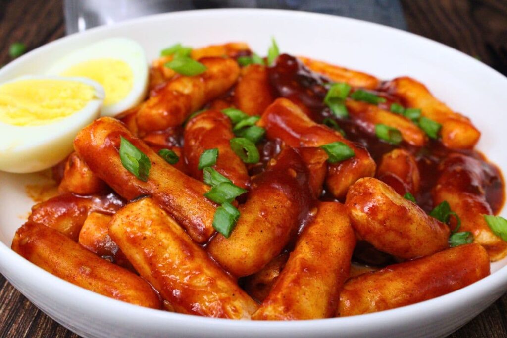closeup view of trader joes air fryer tteokbokki on a plate with a hardboiled egg