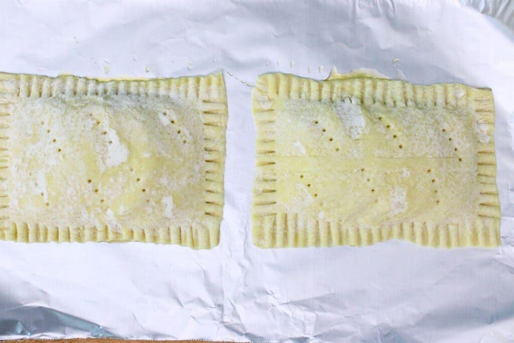 lay puff pastry over each pile of peaches and use a fork to crimp and poke holes