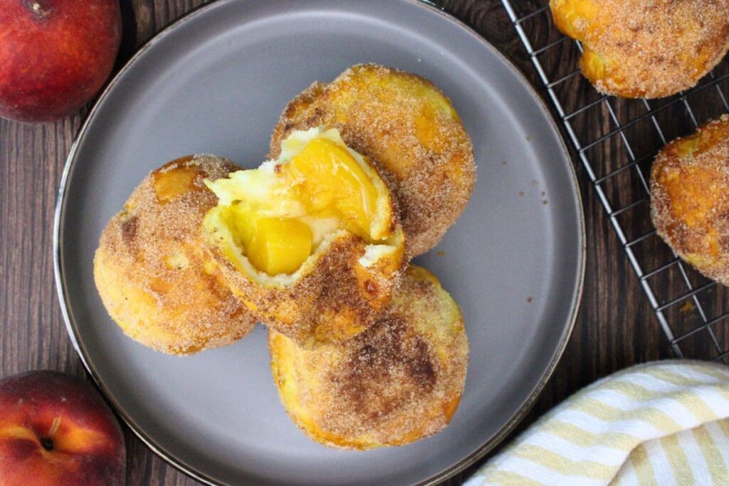 overhead view of air fryer peach pie biscuit bombs stacked up on a plate