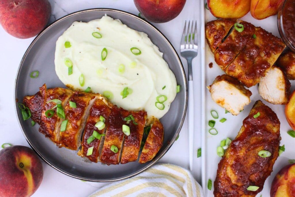 overhead view of air fryer peach whiskey bbq chicken on a plate with mashed potatoes