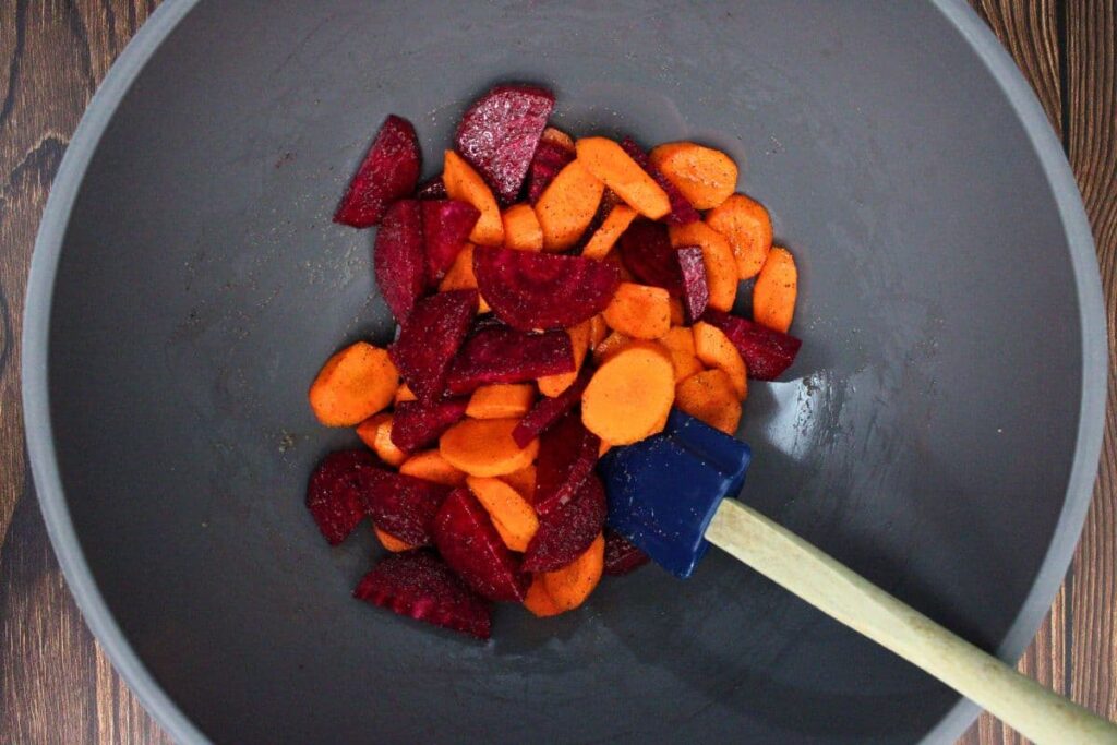 combine beets, carrots, olive oil, salt, and pepper in a mixing bowl
