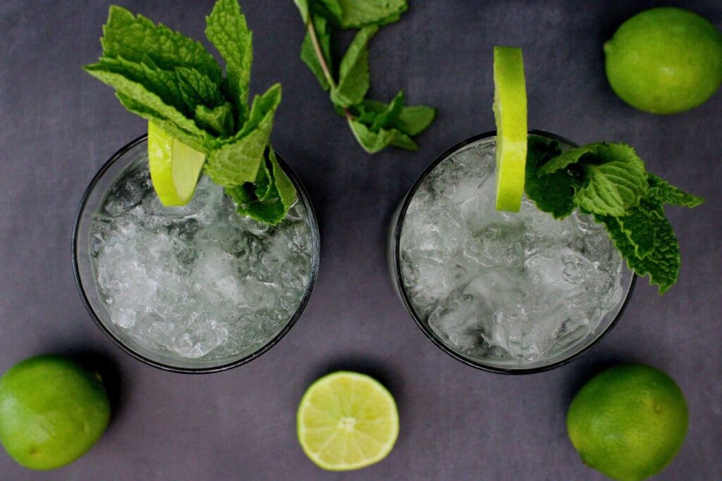 overhead view of two black mojitos garnished with fresh limes