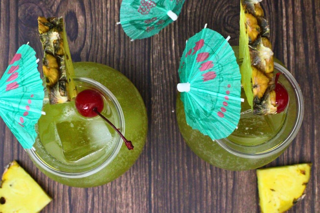 overhead view of two drunken pirate drinks garnished with pineapple and mini umbrellas