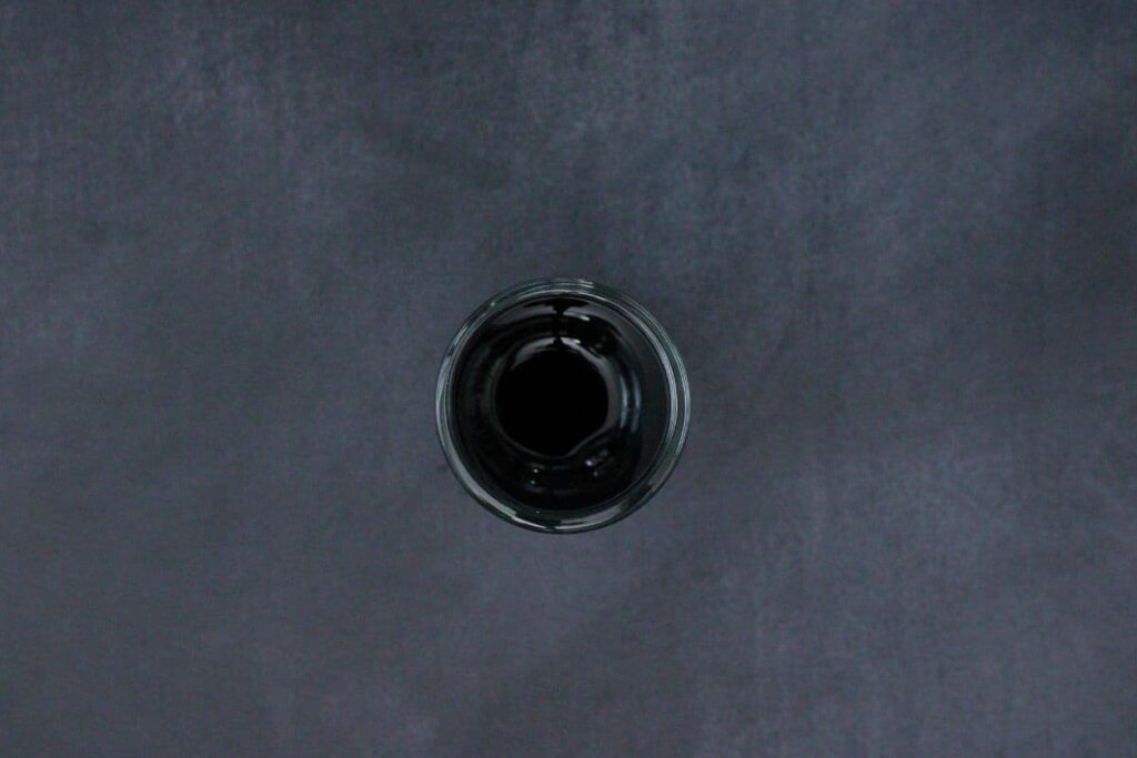 pour creme de cassis in shot glass