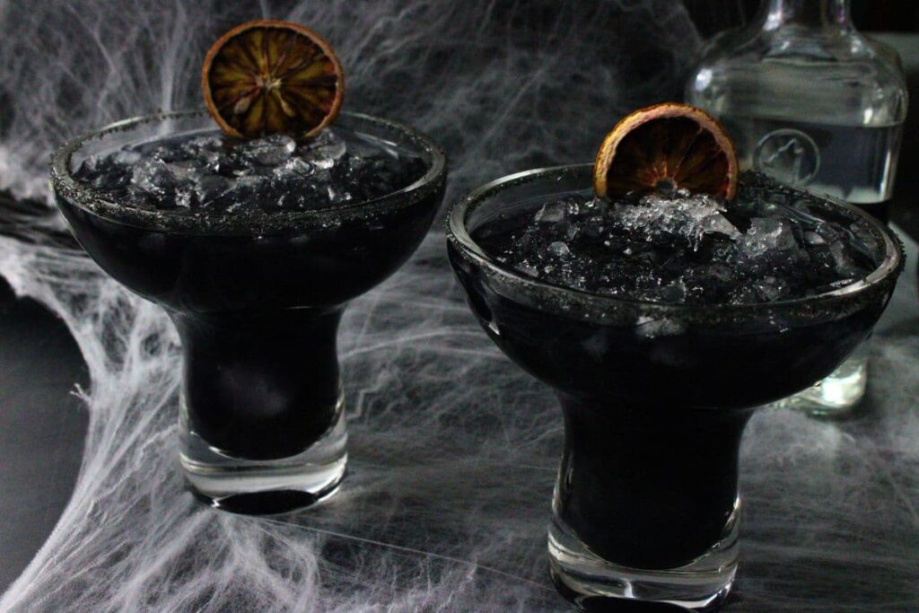 two black margaritas against a spooky spiderweb background