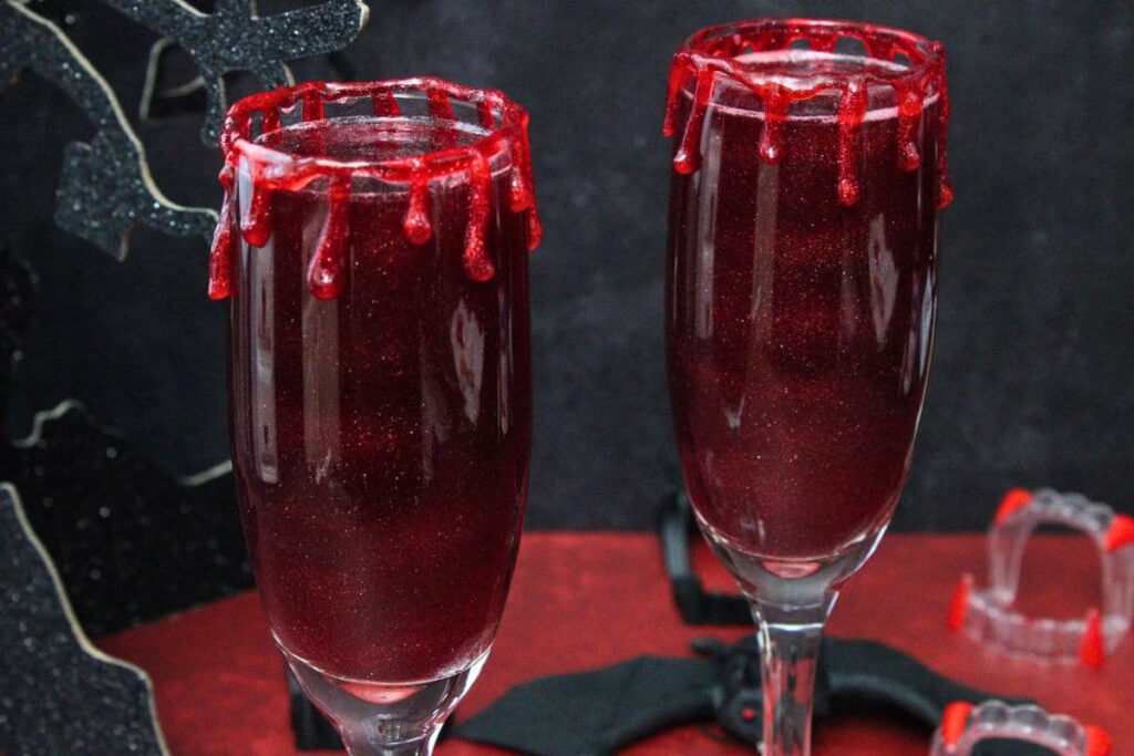 two vampire mimosa cocktails with oozing blood rim