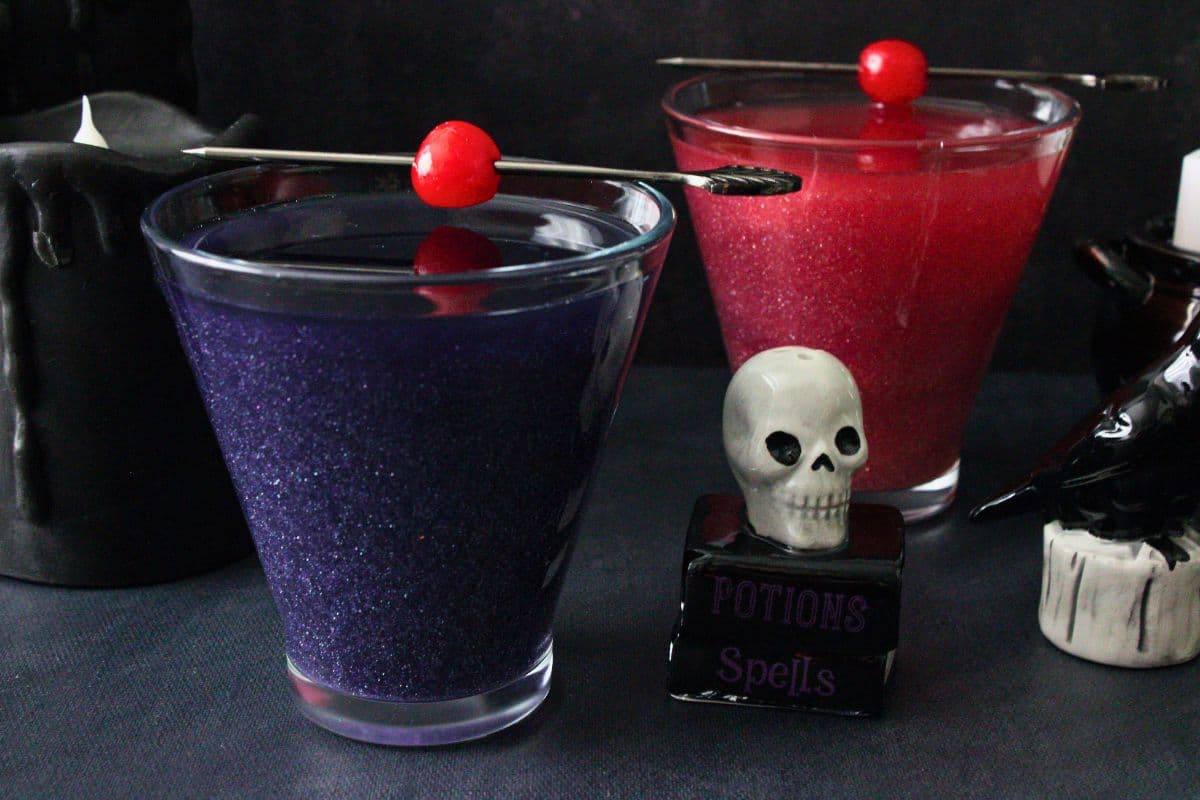 two witch's heart cocktails one purple and one red