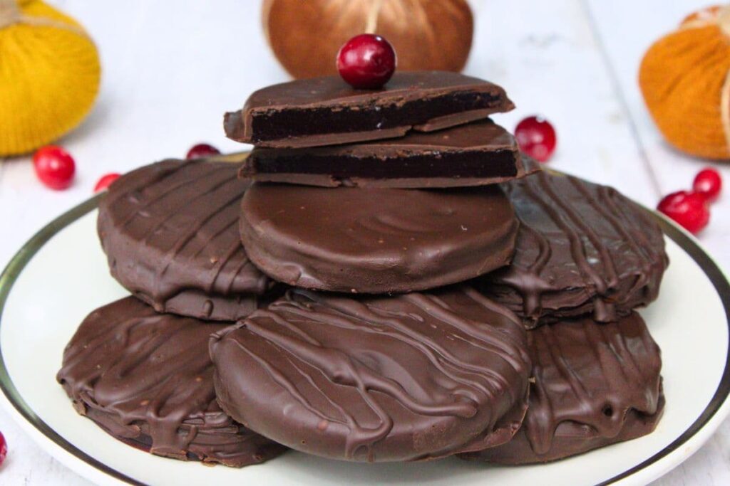 chocolate covered cranberry sauce slices stacked on a plate with one cut in half