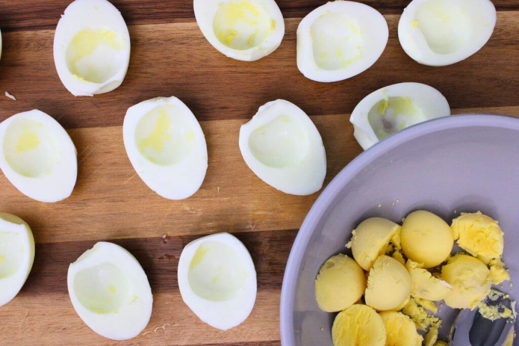 cut eggs in half and scoop yolks into a bowl