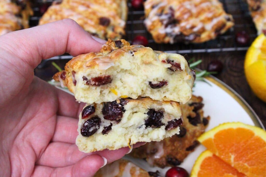 holding up two halves of an air fryer cranberry orange scone