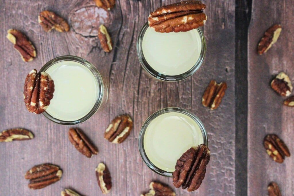 overhead view of three pecan pie shots with fresh pecans